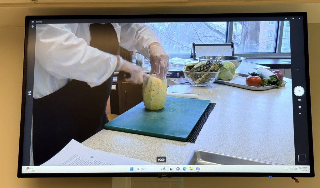 Food demo showing how to cut a pineapple shown on the TV screen
