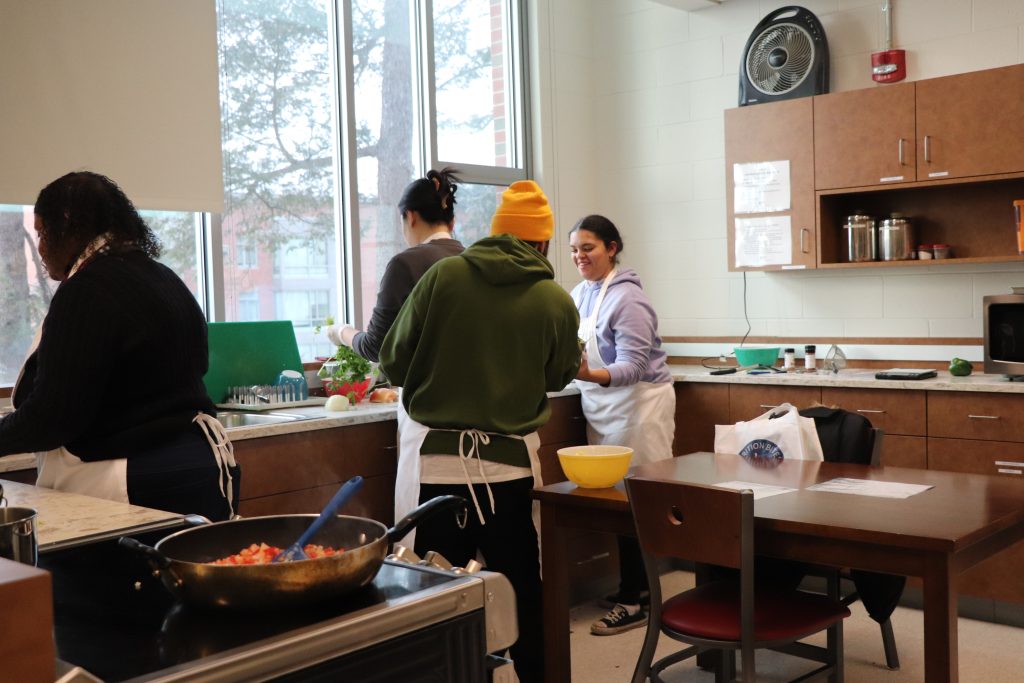 Chef and participants gathered at a culinary work station