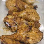 Cooked drumsticks laying side by side on a white dish