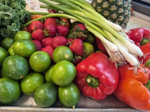 Display of Produce used in Workshop Recipes A display of Peppers, limes, strawberries, kale, scallions, and a pineapple in a tray